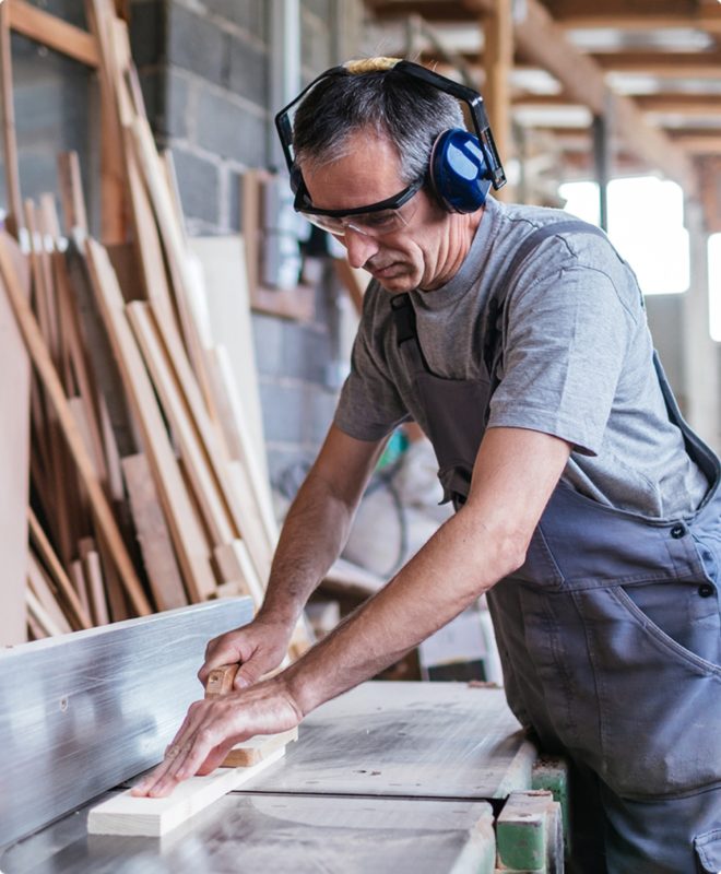 A carpenter wearing noise-cancelling hearing protection works on a new house in New Jersey.