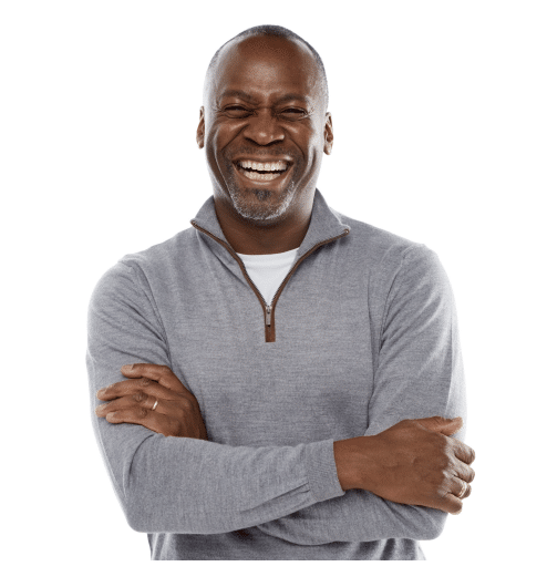 A man laughing in front of a white background happy about his healthy hearing.